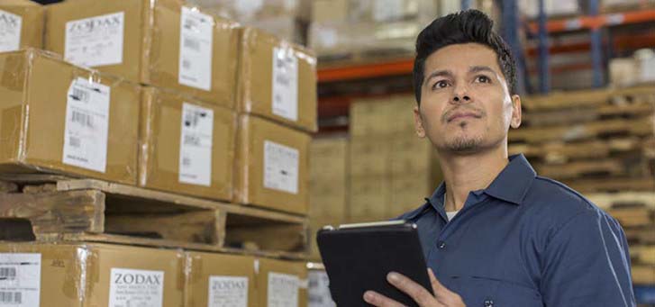 Man with tablet inside a warehouse checking inventory
