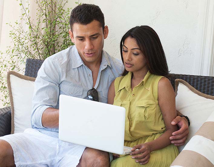 Couple sitting down looking at the laptop