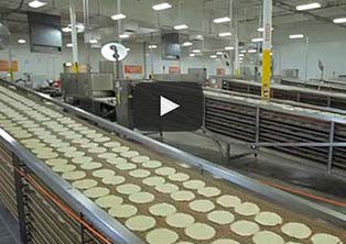 Factory conveyor belt with tortillas on the belt