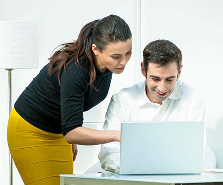 Male and female looking at laptop