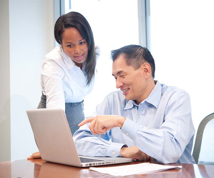 Woman and man looking at a laptop screen