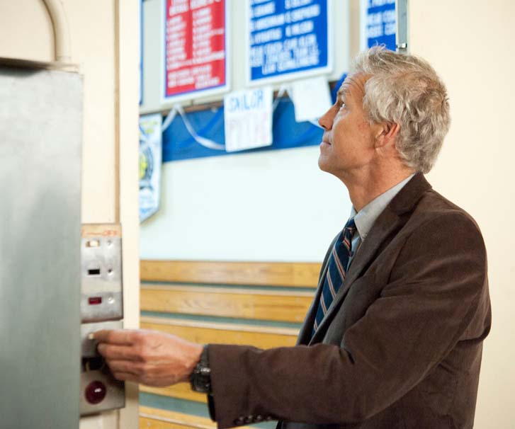 Image of a school-male teacher adjusting lighting in gym