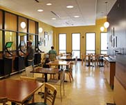 Dining area with tables, chairs and standing computer table.