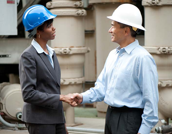 man and woman in hard hats shaking hands