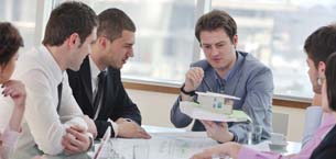 Engineers in a meeting looking at a mock up of a building