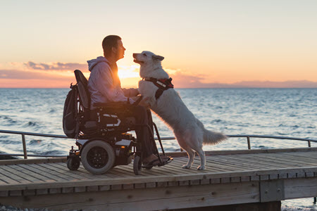 man in electric wheelchair with service dog