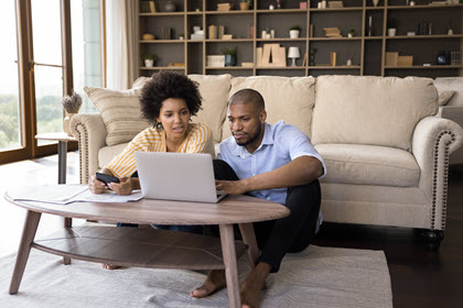 shutterstock image of couple at coffee table looking at laptop