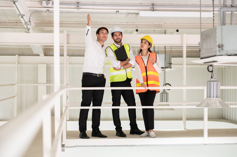 three contractors doing an inspection on a catwalk